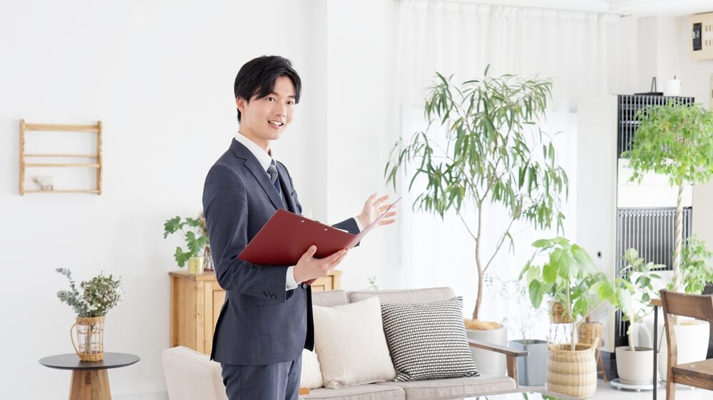 室内を案内する笑顔の男性スタッフ