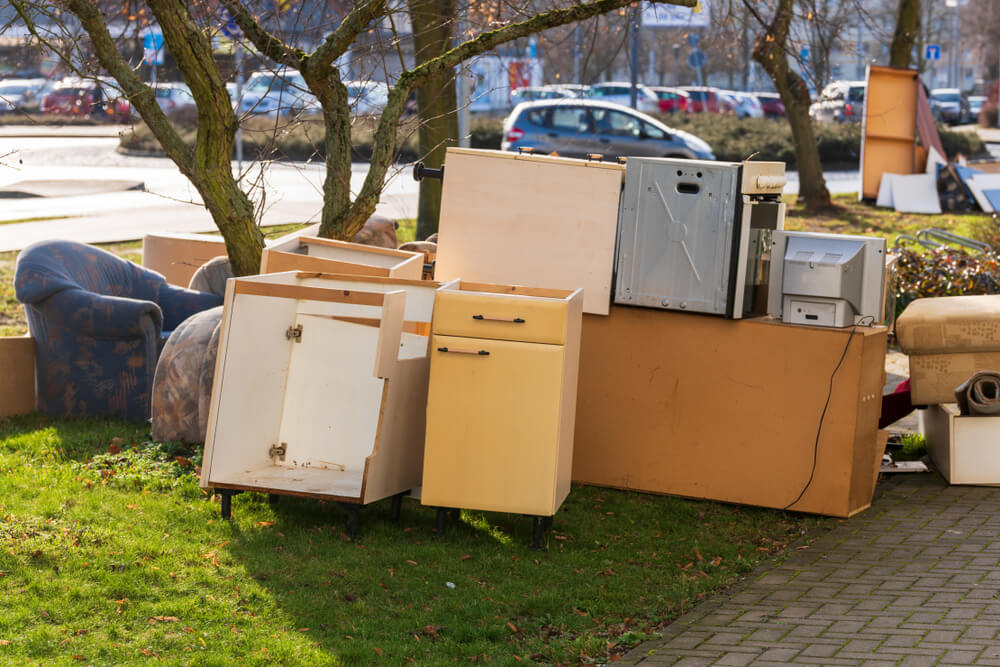 芝生に置かれた古い家具や家電の粗大ごみ