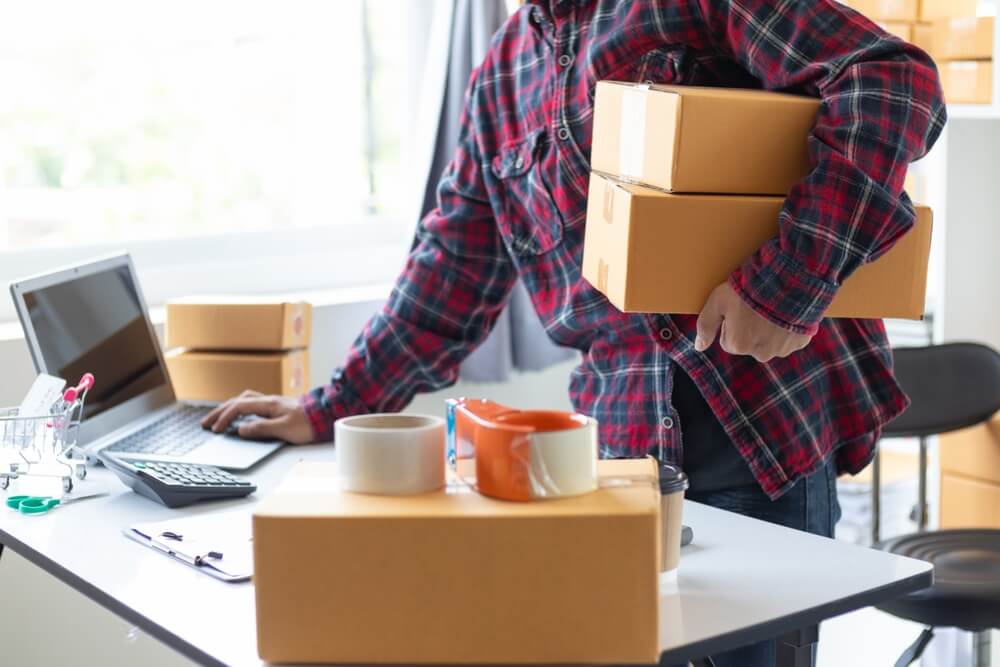 パソコン操作しながら梱包作業をする風景